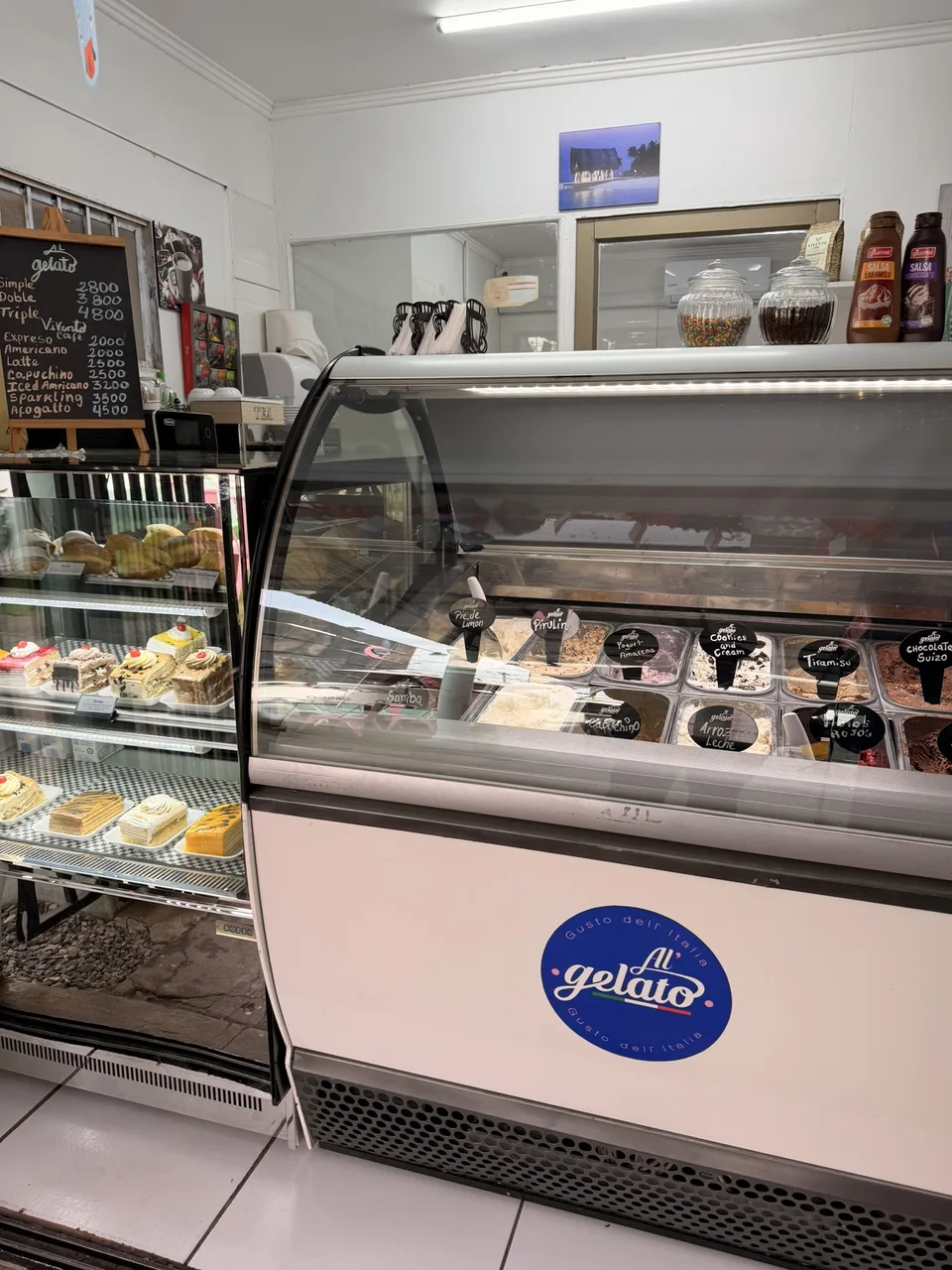 Interior de Al’Gelato con la vitrina de helados y pastelería